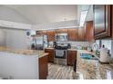 Well-lit kitchen features stainless steel appliances, granite countertops, and wood flooring at 6118 Becklin Pl, Riverview, FL 33578