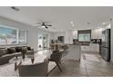 Open-concept living room with stylish furnishings, seamlessly connecting to the kitchen and dining area at 6471 109Th N Ter, Pinellas Park, FL 33782