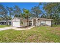 Single-story home with a landscaped yard, walkway to the front door, and attached garage at 7318 Lamplighter St, Spring Hill, FL 34606