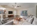 Spacious living room with hardwood floors, a ceiling fan, and access to the patio at 7318 Lamplighter St, Spring Hill, FL 34606