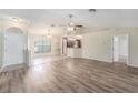 Open-concept living area features wood floors, natural light, and access to other rooms at 7318 Lamplighter St, Spring Hill, FL 34606