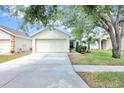Inviting single-story home with a two-car garage, manicured lawn, and mature palm trees at 7855 Bristol Park Dr., Apollo Beach, FL 33572