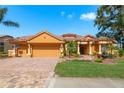 Beautiful home boasts a well-manicured lawn, brick driveway, two-car garage with basketball hoop and lush tropical landscaping at 800 Belted Kingfisher S Dr, Palm Harbor, FL 34683