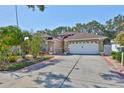 Well-maintained home with a two-car garage, mature trees and landscaping, and a brick-paved driveway at 8916 Southbay Dr, Tampa, FL 33615