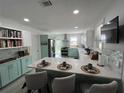 Bright, updated kitchen featuring white and aqua cabinets, granite countertops, and stainless steel appliances at 1003 W Indiana Ave, Tampa, FL 33603