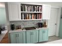 Eat-in kitchen with built-in bookcase, aqua lower cabinets, white upper cabinets and tiled backsplash at 1003 W Indiana Ave, Tampa, FL 33603