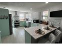 Stylish kitchen with white and aqua cabinets, stainless steel appliances, and a large island with seating at 1003 W Indiana Ave, Tampa, FL 33603