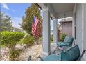 Welcoming front porch with comfortable seating area and an American flag at 11684 Brighton Knoll Loop, Riverview, FL 33579