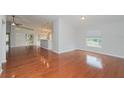 Bright living room featuring gleaming hardwood floors and a kitchen view at 11741 Teapot Ct, Spring Hill, FL 34609