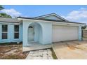 Inviting front entrance with an arched entryway, concrete walkway and a two-car garage at 12019 106Th Ct, Largo, FL 33778