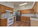 Functional kitchen features oak cabinets, stainless steel refrigerator, and ample counter space at 1246 Ocean Reef Rd, Wesley Chapel, FL 33544