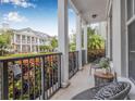 Relaxing porch with seating, iron railing, and vibrant landscaping, offering a pleasant outdoor space at 135 Commonwealth N Ct, St Petersburg, FL 33716