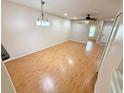 Open-concept living room with laminate wood flooring, ceiling fan, and bright, neutral paint at 15922 Fishhawk Creek Ln, Lithia, FL 33547