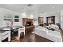 Cozy living room with a charming brick fireplace, hardwood flooring, and ample natural light at 16315 Lonely Ln, Odessa, FL 33556
