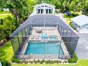Aerial view of a screened-in pool and patio area with seating and lounge chairs at 16603 Hutchison Rd, Odessa, FL 33556