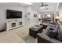 Open-concept living room with modern furnishings, skylights, and a seamless flow to the adjacent dining area at 1820 Rumar Ln, Holiday, FL 34691