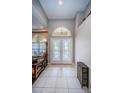 Bright foyer with high ceilings, tile flooring, and decorative glass front doors at 2143 Edelweiss Loop, Trinity, FL 34655