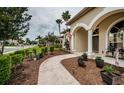 Inviting covered front porch with arched entryway and decorative landscaping at 2143 Edelweiss Loop, Trinity, FL 34655