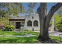 Stunning home showing stucco exterior, arched windows, beautiful greenery, and brick walkway at 2511 W Morrison Ave, Tampa, FL 33629