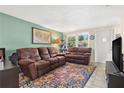 Comfortable living room with brown sofas, a colorful rug, and ample natural light from the windows at 2646 61St N Ave, St Petersburg, FL 33714
