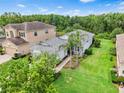 Aerial view of a well-maintained home showcasing its gray roof and landscaping in a lush, green neighborhood at 30410 Ceasar Park Dr, Wesley Chapel, FL 33543