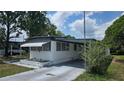 View of this single-story home featuring a carport, and manicured lawn at 37229 Lois Ave, Zephyrhills, FL 33542