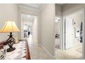 Inviting hallway with neutral tones, tile flooring, and elegant lighting that leads to an open-concept kitchen at 3972 Wisdom Trl, Land O Lakes, FL 34638