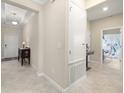 Hallway featuring tiled floor, white walls, and access to a bathroom with a granite countertop at 3972 Wisdom Trl, Land O Lakes, FL 34638