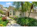 Charming single-Gathering home with mature landscaping, stone walkway, and attached two-car garage at 423 Fan Palm Ne Ct, St Petersburg, FL 33703