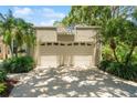 A two-car garage with decorative transom windows sits beneath an elevated terrace at 423 Fan Palm Ne Ct, St Petersburg, FL 33703