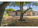 Inviting single-level house boasting stone details and mature trees, creating a warm and welcoming atmosphere at 4608 Deltona Blvd, Spring Hill, FL 34606
