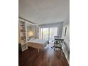 Cozy bedroom with built-in shelving, a Murphy bed, and a dining table at 51 Island Way # 309, Clearwater Beach, FL 33767