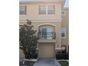 Tan multi-story townhome featuring a front-loading garage and a cozy second-story balcony at 5529 White Marlin Ct, New Port Richey, FL 34652