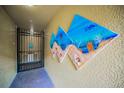 Hallway with beach-themed artwork and a gate leading to a storage area at 5529 White Marlin Ct, New Port Richey, FL 34652