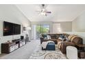 Comfortable living room with vaulted ceilings, plush sectional sofa, large TV, ceiling fan, and balcony access at 5705 Baywater Dr # 5705, Tampa, FL 33615