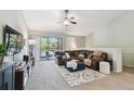 Cozy living room with vaulted ceilings, plush sectional sofa, large TV, ceiling fan, and balcony access at 5705 Baywater Dr # 5705, Tampa, FL 33615