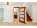 Open doorway reveals the bathroom from the foyer, complemented by staircase and marble tile flooring at 6212 N Grady Ave, Tampa, FL 33614