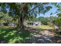 Charming home featuring a screened-in porch and a spacious yard with mature trees at 6226 Florence St, Gibsonton, FL 33534