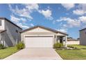 Inviting home featuring a two-car garage, manicured lawn, and beautiful landscaping at 7119 Amelia River Dr, Parrish, FL 34219