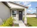 Close-up of the front entrance with stone accents, a black front door, and a landscaped walkway at 7119 Amelia River Dr, Parrish, FL 34219