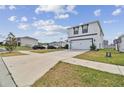 View of a two-story modern home with a two-car garage and a long driveway at 7380 Sail Clover Ln, Zephyrhills, FL 33540
