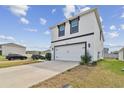 Exterior view of a modern two-story home with a white facade and a two-car garage at 7380 Sail Clover Ln, Zephyrhills, FL 33540