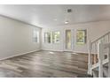 Bright living room with wood floors, large windows, and a decorative front door at 7412 Bridgeview Dr, Wesley Chapel, FL 33545