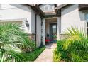 Inviting front entrance with a decorative glass door and lush landscaping at 7912 Yale Harbor Dr, Wesley Chapel, FL 33545