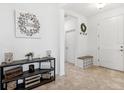 Inviting foyer featuring neutral tile flooring, decorative accents, and a convenient storage bench and access to other rooms at 8496 Starlight Loop, Parrish, FL 34219