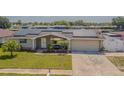 Inviting home exterior features solar panels, a manicured lawn and a two-car garage at 1118 Lodestar Dr, Holiday, FL 34690
