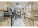 Bright kitchen featuring stainless appliances, granite counters, tile floors and ample cabinet space at 1118 Lodestar Dr, Holiday, FL 34690