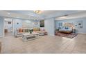 Bright living area featuring tile floors, neutral seating, coastal decor, and a bedroom view at 1210 Bay Pine Blvd, Indian Rocks Beach, FL 33785