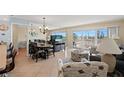 Bright living room with tile floors, dining area, and balcony access at 13440 Gulf Blvd # 202, Madeira Beach, FL 33708