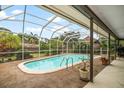 Inviting screened-in pool area with lush greenery, perfect for relaxing and enjoying the outdoors in privacy at 14175 Feather Sound Dr, Clearwater, FL 33762